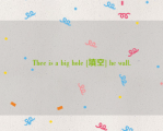 Thee is a big hole [填空] he wall.